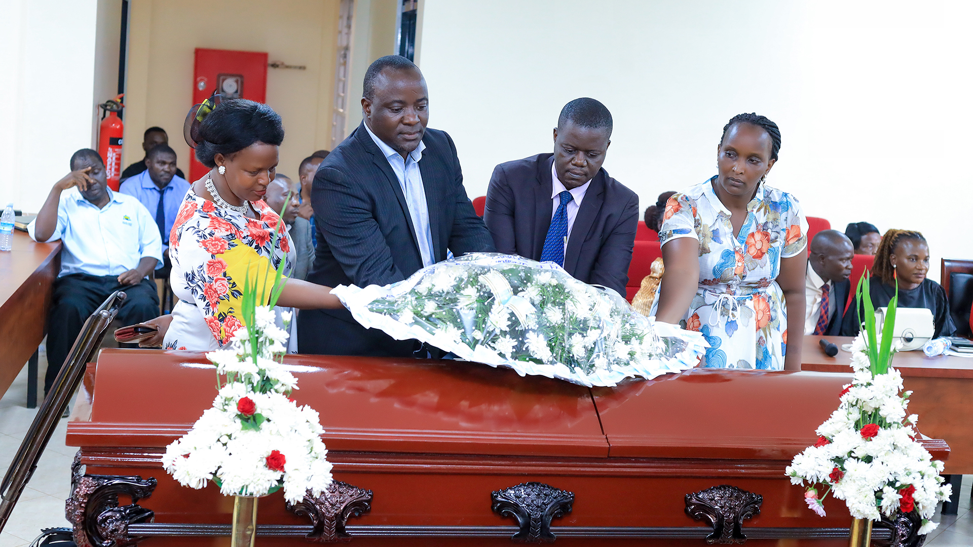 Mukono Deputy Town Clerk Mr. Moses Magemeso , Mr. Jamada Kajoba , the communications officer laying a flower on the late Ssemanda